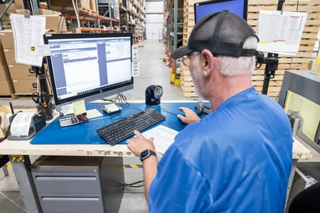A staff member at RiverSide Integrated Solutions inputs data on a computer.