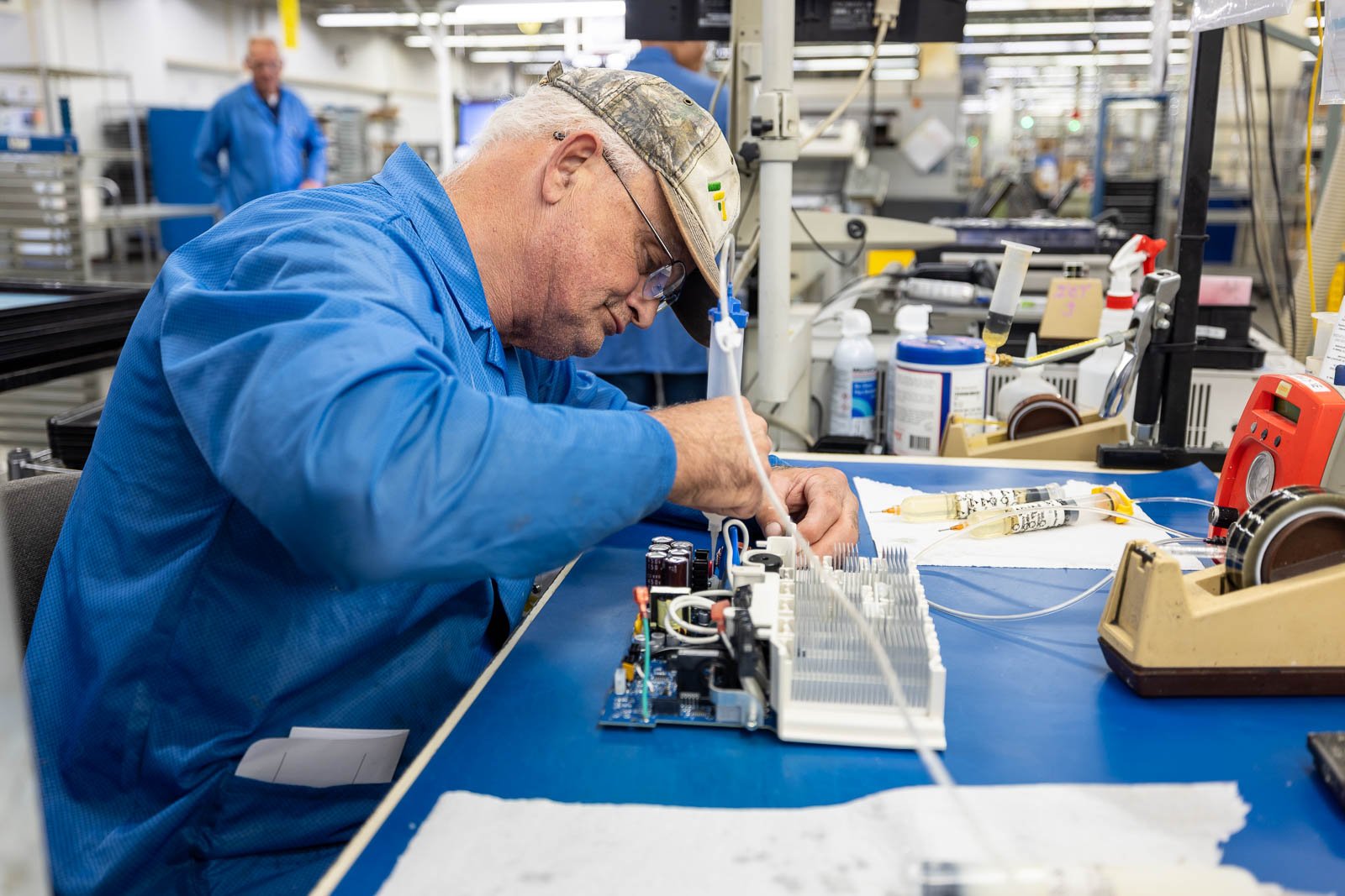 A production worker at RIS completes final inspections on an assembly and adds final coating.