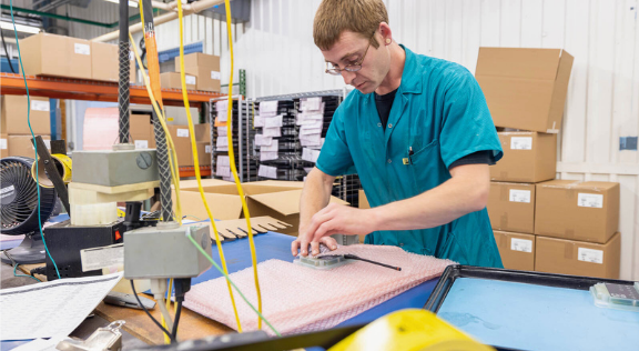 RIS production worker packaging assemblies for fulfillment and distribution.