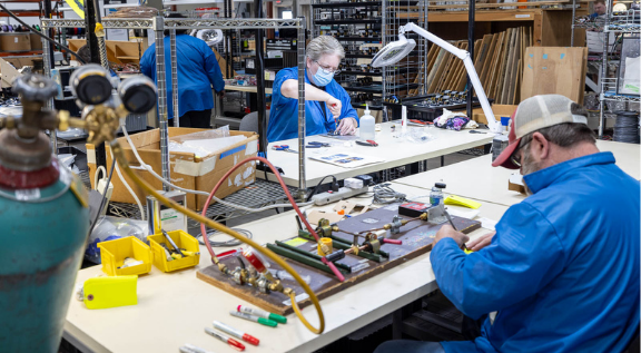 RiverSide production employees work in assembly cells hand assembling complex builds.