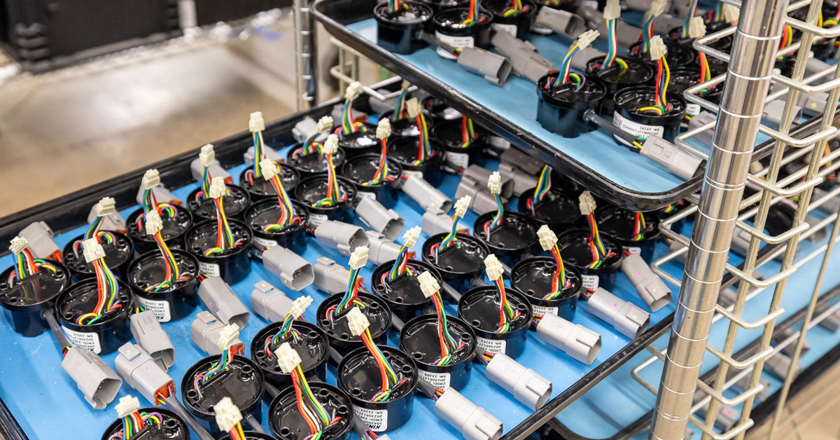 Close up of a fully encapsulated PCBA with wire assemblies attached.